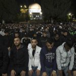 
              Palestinians gather for early morning prayer during the Muslim holy month of Ramadan, shortly before Israeli police clashed with protesters at the Al Aqsa Mosque compound, in Jerusalem's Old City, Friday, April 22, 2022. Israeli police and Palestinian youths clashed again at the major Jerusalem holy site sacred to Jews and Muslims on Friday despite a temporary halt to Jewish visits to the site, which are seen as a provocation by the Palestinians. (AP Photo/Mahmoud Illean)
            
