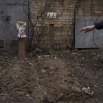 
              A witness gestures next to the grave of two civilians buried in a backyard in Bucha, on the outskirts of Kyiv, Ukraine, Wednesday, April 6, 2022. (AP Photo/Felipe Dana)
            