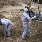 
              Men wearing protective gear exhume the bodies of civilians killed during the Russian occupation in Bucha, on the outskirts of Kyiv, Ukraine, Wednesday, April 13, 2022. Dozens of bodies of civilians executed by the Russian troops have been exhumed already from the mass grave. (AP Photo/Efrem Lukatsky)
            