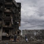 
              An elderly couple walk in front of destroyed apartment buildings in the town of Borodyanka, Ukraine, on Saturday, April 9, 2022. Russian troops occupied the town of Borodyanka for weeks. Several apartment buildings were destroyed during fighting between the Russian troops and the Ukrainian forces in the town around 40 miles northwest of Kiev. (AP Photo/Petros Giannakouris)
            