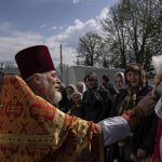 
              An Orthodox priest blesses believers during the Easter celebration at the All Saints church in Bahmut, eastern Ukraine, Sunday, April 24, 2022. (AP Photo/Evgeniy Maloletka)
            