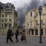 
              People walk in a street as smoke rises in the air after shelling in Odesa, Ukraine, Sunday, April 3, 2022. (AP Photo/Petros Giannakouris)
            
