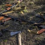 
              Rifles and an axe lay in a field where Ukrainian soldiers dig a trench in case of another Russian invasion, in Bucha, on the outskirts of Kyiv, Ukraine, Thursday April 14, 2022. (AP Photo/Rodrigo Abd)
            