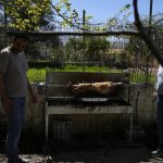 
              The Easter lamb is spit-roasted as Alexandros Ehrmann, left, smiles to his son Giorgos-Filippos and Christina Anastasopoulou, right, holds her daughter Amelia next to her father Giorgos, in Myrodafni village, Epirus region, northwestern Greece, on Sunday, April 24, 2022. For the first time in three years, Greeks were able to celebrate Easter without the restrictions made necessary by the coronavirus pandemic. (AP Photo/Thanassis Stavrakis)
            
