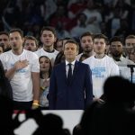 
              French President Emmanuel Macron and centrist candidate for reelection, center, sings the national anthem during a meeting in Paris, Saturday, April 2, 2022. France's first round of the presidential election will take place on April 10, with a presidential runoff on April 24 if no candidate wins outright. (AP Photo/Francois Mori)
            