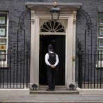 
              A police officer knocks on the door of 10 Downing Street in London, Tuesday, April 12, 2022. U.K. Prime Minister Boris Johnson's office says he will be issued a fine for breaching COVID-19 regulations following allegations of lockdown parties at government offices. Treasury Chief Rishi Sunak will also be fined. (AP Photo/Kirsty Wigglesworth)
            