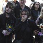 
              People cry during a funeral ceremony for Kira Glodan, three-month-old, her mother Valerya Glodan, 28, and grandmother Lyudmila Yavkina, 54, killed in their apartment by shelling, at the Transfiguration Cathedral in Odessa, Ukraine, Wednesday, April 27, 2022. According Ukrainian officials five people including a three-month-old infant were killed and 18 injured in a missile attack in the Black Sea port city of Odesa on last Saturday, April 23. (AP Photo/Max Pshybyshevsky)
            