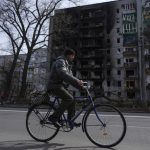 
              A man rides a bicycle past an apartment building damaged by shelling of Russian forces on the outskirts of Chernihiv, Ukraine, Thursday, April 7, 2022. (AP Photo/Evgeniy Maloletka)
            