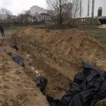 
              Neighbours gather next to a mass grave in Bucha, in the outskirts of Kyiv, Ukraine, Sunday, April 3, 2022. (AP Photo/Rodrigo Abd)
            