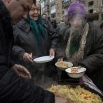
              Neighbours receive free food from a soup kitchen in Bucha, in the outskirts of Kyiv, Ukraine, Saturday, April 9, 2022. (AP Photo/Rodrigo Abd)
            