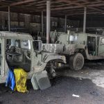 
              FILE - Damaged Ukrainian army military vehicles with a Ukrainian national flag, are seen at the partly destroyed Illich Iron & Steel Works Metallurgical Plant, in an area controlled by Russian-backed separatist forces in Mariupol, Ukraine, Monday, April 18, 2022. On Thursday, April 21, 2022, Russian President Vladimir Putin ordered his forces not to storm the last remaining Ukrainian stronghold in the besieged city of Mariupol but to block it “so that not even a fly comes through.” (AP Photo/Alexei Alexandrov, File)
            