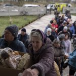 
              People receive food from a church in the town of Borodyanka, about 40 miles northwest of Kyiv, Ukraine, on Sunday, April 10, 2022. Several apartment buildings were destroyed during fighting between the Russian troops and the Ukrainian forces and the town is without electricity, water and heating. (AP Photo/Petros Giannakouris)
            