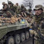 
              A Ukrainian serviceman walks next to a fighting vehicle, outside Kyiv, Ukraine, Saturday, April 2, 2022. As Russian forces pull back from Ukraine's capital region, retreating troops are creating a "catastrophic" situation for civilians by leaving mines around homes, abandoned equipment and "even the bodies of those killed," President Volodymyr Zelenskyy warned Saturday.(AP Photo/Vadim Ghirda)
            
