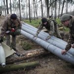 
              Ukrainian soldiers examine Russian multiple missiles abandoned by Russian troops when they retreated after recent fights in the village of Berezivka, Ukraine, Thursday, Apr. 21, 2022. (AP Photo/Efrem Lukatsky)
            