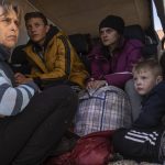 
              From left to right, Oksana Gavrielutca 41, sits at the back of a bus with her children Oleg 18, Diana 17 and Vlad 5 after they flee from Snigiriovka village, in Mikolaiv district, Ukraine, on Thursday, April 7, 2022. (AP Photo/Petros Giannakouris)
            