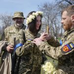 
              Vyacheslav, a Ukrainian soldier, puts a wedding ring on Anastasia's finger during their wedding ceremony in a city park in Kyiv, Ukraine, Thursday, April 7, 2022. (AP Photo/Efrem Lukatsky)
            
