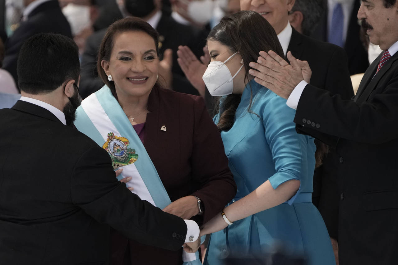 FILE - President Xiomara Castro smiles as she receives the presidential sash, as her husband former...