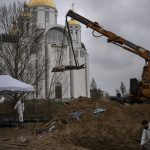 
              A crane lifts the corpse of a man from a mass grave to be identified in a morgue, in Bucha, on the outskirts of Kyiv, Ukraine, Sunday, April 10, 2022. (AP Photo/Rodrigo Abd)
            