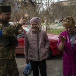 
              Chaplain Dmitri blesses a group of neighbors in Bucha, in the outskirts of Kyiv, Ukraine, Friday, April 8, 2022. (AP Photo/Rodrigo Abd)
            