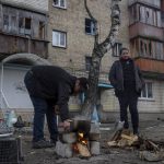 
              Oleksander Radkevich, 41, cooks on a makeshift fire next to his wife Irina Shekhovtsova outside their destroyed apartment building in the town of Borodyanka, Ukraine, on Saturday, April 9, 2022. Russian troops occupied the town of Borodyanka for weeks. Several apartment buildings were destroyed during fighting between the Russian troops and the Ukrainian forces in the town around 40 miles northwest of Kiev. (AP Photo/Petros Giannakouris)
            
