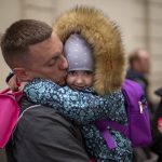 
              Ukrainian Nicolai, 41, says goodbye to his daughter Elina, 4, next to his wife Lolita, right, before boarding in a train bound for Poland fleeing from the war at the train station in Lviv, western Ukraine on Friday, April 15, 2022. (AP Photo/Emilio Morenatti)
            