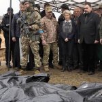 
              EU Commission President Ursula von der Leyen, center, looks at covered bodies of killed civilians in Bucha, on the outskirts of Kyiv, Ukraine, Friday, April 8, 2022. (AP Photo/Efrem Lukatsky)
            