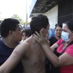 
              A woman talks to her son who has been arrested by the police, as he is taken to El Penalito temporary prison in Ciudad Delgado, El Salvador, Wednesday, April 6, 2022. El Salvador's President Nayib Bukele's has declared a state of emergency in a crackdown against gangs, suspending constitutional guarantees of freedom of assembly and loosening arrest rules for as much as thirty days. (AP Photo/Salvador Melendez)
            