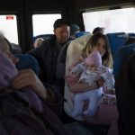 
              Anastasia Vizavik holds one of her six children inside a bus at the city of Bashtanka, Mykolaiv district, Ukraine, on Thursday, April 7, 2022. Vizavik and her family are fleeing the town of Chernobaievka in Kherson province, which is occupied by the Russian forces. (AP Photo/Petros Giannakouris)
            