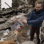 
              Dmitriy Evtushkov, 25, points to his picture in a primary school album retrieved from the rubble of an apartment building destroyed during fighting between Ukrainian and Russian forces in Borodyanka, Ukraine, Tuesday, April 5, 2022. Ukrainian President Volodymyr Zelenskyy accused Russian troops of gruesome atrocities in Ukraine and told the U.N. Security Council on Tuesday that those responsible should immediately be brought up on war crimes charges in front of a tribunal like the one set up at Nuremberg after World War II. (AP Photo/Vadim Ghirda)
            