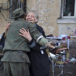 
              A local woman embraces a serviceman of Donetsk People's Republic militia near a damaged apartment building in an area controlled by Russian-backed separatist forces in Mariupol, Ukraine, Tuesday, April 26, 2022. (AP Photo/Alexei Alexandrov)
            