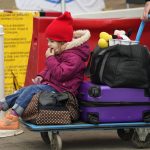 
              Milana Gudkovskaya, 3, sits on a trolley after fleeing the war from neighbouring Ukraine at the border crossing in Medyka, southeastern Poland, Wednesday, April 6, 2022. (AP Photo/Sergei Grits)
            
