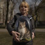 
              Irina poses with her cat Alitsia, after she went back into the embattled town of Irpin to retrieve it, on the outskirts of Kyiv, Ukraine, Thursday, March 31, 2022. Heavy fighting raged on the outskirts of Kyiv and other zones Thursday amid indications the Kremlin is using talk of de-escalation as cover while regrouping and resupplying its forces and redeploying them for a stepped-up offensive in eastern Ukraine. (AP Photo/Vadim Ghirda)
            