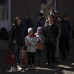 
              People wait to take the bus at the city of Bashtanka, Ukraine, after fleeing from nearby villages which have been attacked by the Russian forces in the Mykolaiv district, on Thursday, April 7, 2022. (AP Photo/Petros Giannakouris)
            