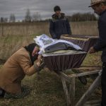 
              Nadiya Trubchaninova, 70, cries while holding the coffin of her son Vadym, 48, who was killed by Russian soldiers last March 30 in Bucha, during his funeral in the cemetery of Mykulychi, on the outskirts of Kyiv, Ukraine, Saturday, April 16, 2022. After nine days since the discovery of Vadym's corpse, finally Nadiya could have a proper funeral for him. This is not where Nadiya Trubchaninova thought she would find herself at 70 years of age, hitchhiking daily from her village to the shattered town of Bucha trying to bring her son's body home for burial. (AP Photo/Rodrigo Abd)
            