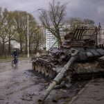 
              A man rides his bicycle next to a destroyed Russian tank in Chernihiv, Ukraine, on Thursday, April 21, 2022. (AP Photo/Emilio Morenatti)
            