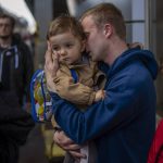 
              Oleksandr, 26 kisses his soon Egor, 2, as they meet at the train station after more than two months separated for the war in Kyiv, Ukraine on Saturday, April 23, 2022. (AP Photo/Emilio Morenatti)
            