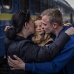 
              Oleksandr, 26 kisses his soon Egor, 2, and his wife Alyona, 26, as they meet at the train station after more than two months separated for the war in Kyiv, Ukraine on Saturday, April 23, 2022. (AP Photo/Emilio Morenatti)
            