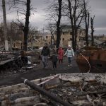 
              A family walks amid destroyed Russian tanks in Bucha, on the outskirts of Kyiv, Ukraine, Wednesday, April 6, 2022. (AP Photo/Felipe Dana)
            