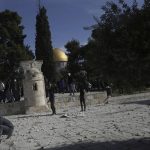 
              Palestinians gather stones to throw at Israeli police after they entered the Al Aqsa Mosque compound, in Jerusalem's Old City, Friday, April 22, 2022. (AP Photo/Mahmoud Illean)
            