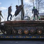 
              Road workers load a destroyed Russian tank onto a platform in the village of Andriyivka close to Kyiv, Ukraine, Monday, April 11, 2022. Andriyivka was occupied by the Russian troops at the beginning of the Russia-Ukraine war and freed recently by the Ukrainian army. (AP Photo/Efrem Lukatsky)
            