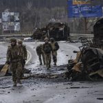
              Ukrainian soldiers walk next to destroyed Russians armored vehicles in Boucha, Ukraine, Saturday, April 2, 2022. (AP Photo/Rodrigo Abd)
            
