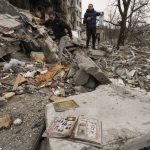 
              People look for personal belongings in the rubble of an apartment building destroyed during fighting between Ukrainian and Russian forces in Borodyanka, Ukraine, Tuesday, April 5, 2022. Ukrainian President Volodymyr Zelenskyy accused Russian troops of gruesome atrocities in Ukraine and told the U.N. Security Council on Tuesday that those responsible should immediately be brought up on war crimes charges in front of a tribunal like the one set up at Nuremberg after World War II. (AP Photo/Vadim Ghirda)
            