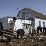 
              People clean derbis in the yard of a damaged house following a Russian bombing earlier in the week,  on the outskirts of Mykolaiv, Ukraine, on Friday, April 1, 2022. (AP Photo/Petros Giannakouris)
            