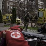 
              Ukrainian servicemen run for cover as explosions are heard during a Russian attack in downtown Kharkiv, Ukraine, Sunday, April 17, 2022. (AP Photo/Felipe Dana)
            