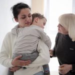 
              Karina Buiukli, 27-years-old, holds her 2-year-old son, Maxim as her mother Galina Stepanova, right, watches after an interview with The Associated Press, in Brasov, Romania, Wednesday, March 30, 2022. Having escaped from Russian shelling, Ukrainian refugees are now focused on building new lives — temporarily or permanently. Countries neighboring their homeland, like Poland and Romania, are sparing no effort to help them integrate and feel needed in the new environment.(AP Photo/Stephen McGrath)
            