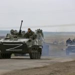 
              Russian military vehicles move on a highway in an area controlled by Russian-backed separatist forces near Mariupol, Ukraine, Monday, April 18, 2022. Mariupol, a strategic port on the Sea of Azov, has been besieged by Russian troops and forces from self-proclaimed separatist areas in eastern Ukraine for more than six weeks. (AP Photo/Alexei Alexandrov)
            