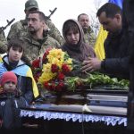 
              Relatives and friends stand by the coffins of Ukrainian servicemen Yuri Filyuk, 49, and Oleksander Tkachenko, 33, during a funeral ceremony in a village of Oleksandrivka, Odesa region, Ukraine, Tuesday, April 12, 2022. According to Ukrainian servicemen, these two were killed by a Russian missile hit their military base in Krasnoselka, Odesa region, on April 7. (AP Photo/Max Pshybyshevsky)
            