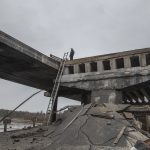 
              Ukrainian serviceman stand on a destroyed bridge between the village of Dytiatky and Chernobyl, Ukraine, Tuesday, April 5, 2022. (AP Photo/Oleksandr Ratushniak)
            