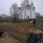 
              Journalists take pictures next to a mass grave in Bucha, in the outskirts of Kyiv, Ukraine, Sunday, April 3, 2022. (AP Photo/Rodrigo Abd)
            