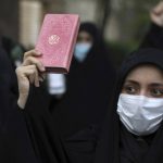 
              A protester holds a copy of the Quran, the Muslims holy book, during a demonstration to condemn planned Quran burnings by a right-wing group in Sweden, in front of the Swedish Embassy in Tehran, Iran, Monday, April 18, 2022. Sweden has seen unrest, scuffles and violence since Thursday, triggered by Danish far-right politician Rasmus Paludan's meetings and planned Quran burnings across the country. (AP Photo/Vahid Salemi)
            
